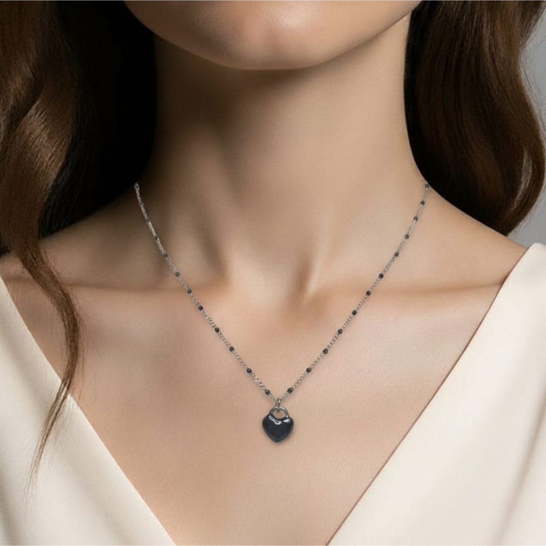 Collar de acero inoxidable con dije de corazón convexo esmaltado en negro.