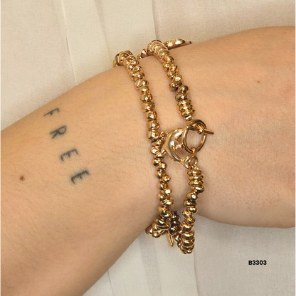 Gold bracelet with metal beads and decorative charms