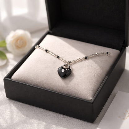 Collar de acero inoxidable con dije de corazón convexo esmaltado en negro.